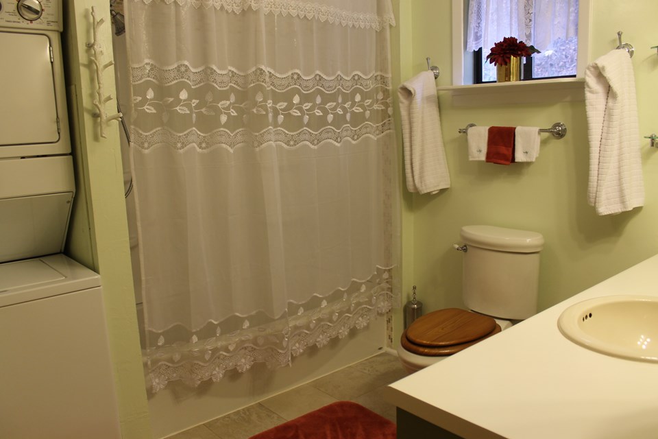 bath with tub/shower combo and stackable washer and dryer